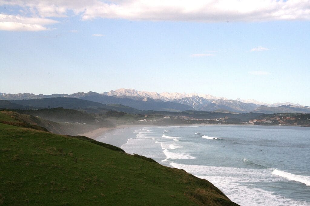 Das Foto zeigt eine Landschaft, in welcher Berge auf Meer treffen. Die Stimmung ist schön, denn die Sonne ist noch nicht aufgegangen.